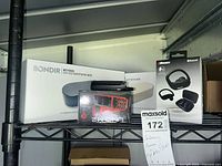 Bondir sanitizing box, 2Boom earbuds box and partial view of phones on shelf