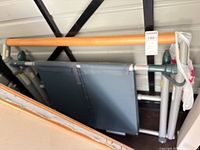 Overall view of folded Fluidity barre showing wood bar, gray frame, wheels