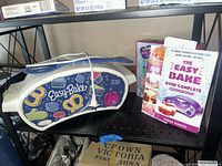 Front view of Easy-Bake oven, cookbook, nail kit partially visible