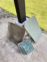 Two large flat stone slabs and stack of small green square tiles