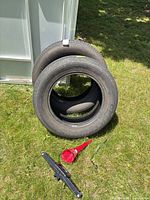 Two Toyo tires stacked upright with jack and funnel visible