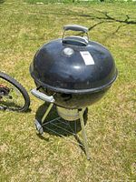 Full view of kettle grill with lid and wheels