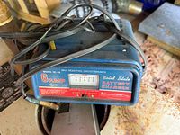 Front view of blue solid state battery charger with cords