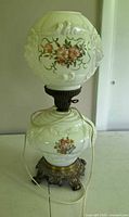 Front view showing entire lamp with globe shade, floral pattern, and cord