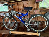 Full view of blue and silver NEXT Break Point Pro mountain bike hanging in garage