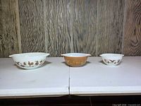 Three Pyrex Early American mixing bowls showing size graduation and color variations