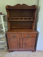 Front view of wooden hutch showing shelves, drawers and doors