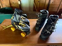 Both pairs of roller skates on table