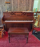 Front view of Wurlitzer spinet piano with bench