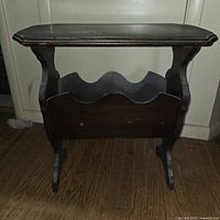 Full view of wooden magazine side table showing top, legs and magazine rack