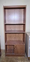 Front view of entire bookcase showing shelves, cubby, and cabinet door