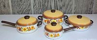 Group shot of all four lidded enamel pots