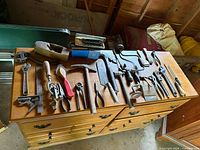 Full assortment of vintage hand tools laid out on dresser top