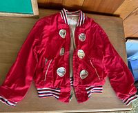 Full view of red kids varsity jacket with team patches
