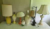 Group of seven vintage lamps displayed on table