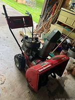 Full view of Yard Machines snow blower showing auger housing, chute, handle assembly, flat front tire