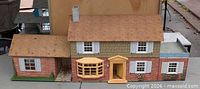 Front view of full tin litho house showing central section and two wings