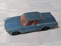 Left front quarter view of blue Corgi Buick Riviera model showing overall condition and paint loss