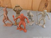 Front view of five Marx caveman figures in various poses