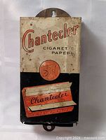 Front view of Chantecler cigarette paper dispenser showing graphics and mounting slot