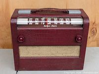 Front view of burgundy Northern Electric Sportsman radio showing speaker grille and knobs