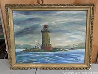 Full view of framed lighthouse oil painting