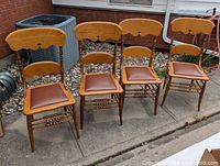 Front view of all four oak press-back chairs