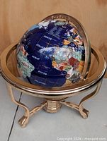 Full view of gemstone globe on brass stand