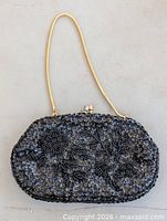 Full view of black beaded evening purse showing chain handle and clasp