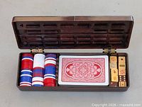Open case showing poker chips, playing cards, dice
