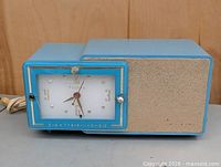 Front view showing clock face and speaker grille