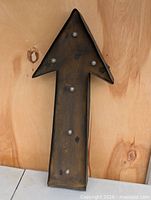 Full view of metal arrow sign showing shape and bulb placement