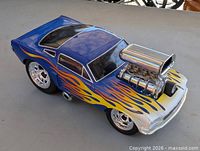 Left front view showing overall car, flame paint, wheels, supercharger