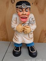 Front view of Dr. Giggles dentist statue standing on table