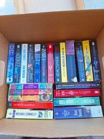 Box of standing paperbacks showing spine titles and authors