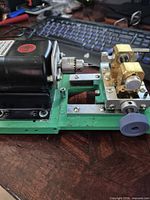 Side view of Baoshishan pearl drilling machine on green base showing motor, chuck and brass clamp