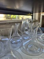 Multiple clear glass wine decanters on shelf, front view