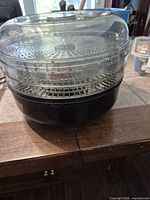 Complete dehydrator assembled showing black base and three clear trays