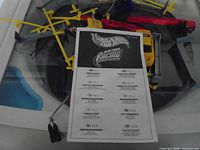 instruction manual laying over assortment of yellow guardrails, cars and power pack