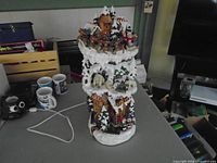 Full view of lighted resin village tower with power cord