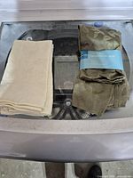 Two folded napkin stacks, one ivory, one olive green with blue band