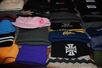 Grid of 20 knit hats showing colours, logos and styles