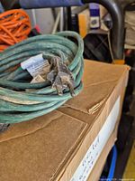 Close-up of green cord male 3-prong plug and cable condition