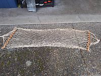 Natural cotton rope hammock laid out showing spreader bars and netting