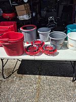 Overall group of buckets and wringer inserts on table