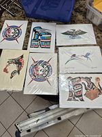 Overview of six prints in sleeves on tabletop