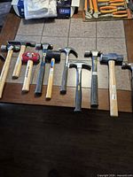 Row of assorted hammers and mallet on table