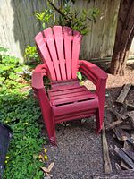 Front view of red plastic Adirondack chair showing slatted back and seat