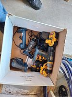 Box containing drill/driver, flashlights, batteries, cords