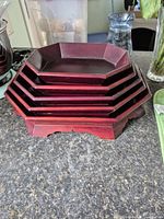 Stacked view of all five trays showing octagonal shape and red finish
